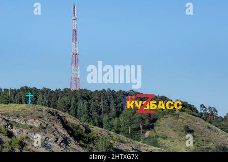 L'iscrizione Kuzbass sulla montagna di fronte alla foresta sulla cima della quale una grande lettera Z è scritta in rosso, fuoco selettivo Foto Stock