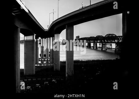 Scatto in scala di grigi di un ponte costiero sotto un cielo cupo Foto Stock