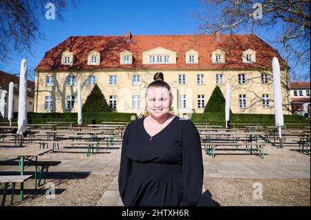 28 febbraio 2022, Brandeburgo, Großbeeren: Salina Worm, amministratore delegato di Schloss Diedersdorf, si trova di fronte al castello del padre. Egli ha citato in giudizio lo Stato di Brandeburgo per una compensazione insufficiente durante le chiusure di Corona. La causa è stata deferita alla Corte federale di giustizia il 03.03.2022. Foto: Annette Riedl/dpa Foto Stock