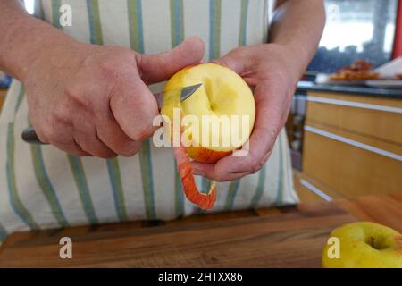 Cucina sveva, preparazione frittelle di mele, buccia mela, frutta per dessert, dessert, Dessert, mani degli uomini, coltello, Germania Foto Stock