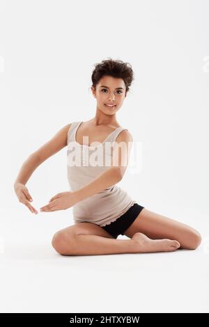 Ballare è la sua passione e si sforza di essere la migliore. Una ballerina adolescente carina in posa in studio con un grande sorriso sul suo volto. Foto Stock