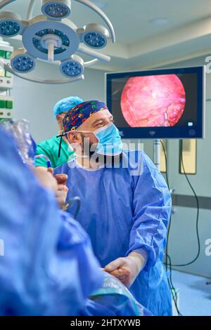 i medici nella sala operatoria eseguono interventi chirurgici su un paziente Foto Stock