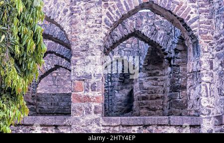 Archi in pietra curvi all'interno delle rovine del forte Golconda, una cittadella fortificata costruita nel 16 il secolo dalla dinastia Qutb Shani. Foto Stock