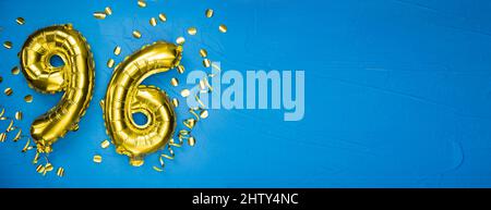 palloncino giallo dorato su fondo di cemento blu numero novantasei. Tessera di compleanno o anniversario con iscrizione 96. Celebrazione dell'anniversario. B Foto Stock