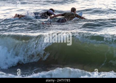 I surfisti si fermerono alla formazione per una sessione di surf all'alba a Jacksonville Beach nel nord-est della Florida. (USA) Foto Stock