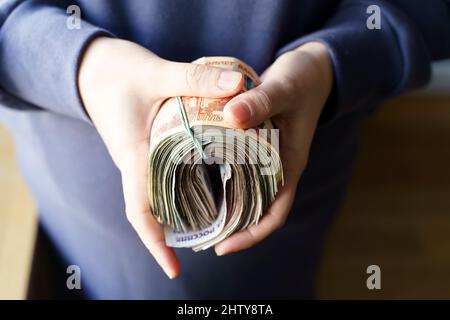 La Russia rubbe le banconote in mano durante la guerra in Ucraina. Inflazione, sanzioni e caduta del concetto di economia russa. Risparmio e budget in calo. Foto di alta qualità Foto Stock