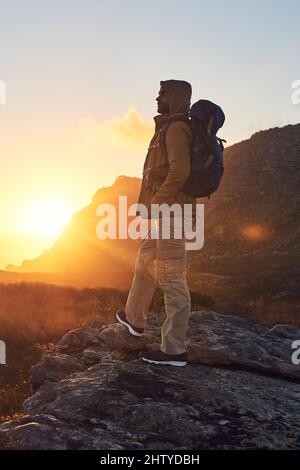 La meraviglia del mondo. Scatto di un escursionista sulla cima di una montagna che si gode la vista del sole del mattino. Foto Stock