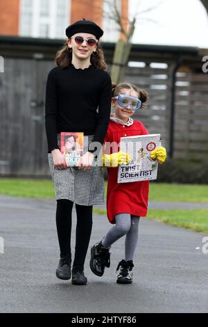 Chichester, West Sussex, Regno Unito. 03rd Mar 2022. Firenze, 6, vestita in rosso come Ada Twist Scientist, un libro di Andrea Beaty e illustrato da David Roberts, e sua sorella Isabelle, 10, vestita in nero come Agatha Oddlyon, un personaggio di un libro di Lena Jones. Sia sul loro senso a scuola vestito in su ed avere divertimento durante la Giornata Mondiale del Libro. Credit: Sam Stephenson/Alamy Live News Foto Stock