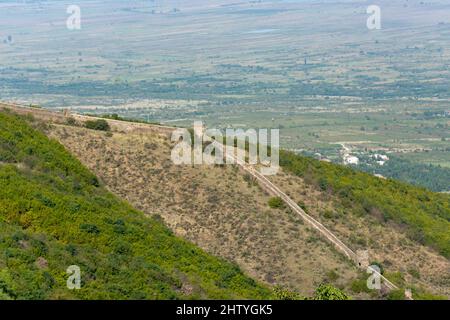 Vista di una sezione delle mura della città di Sighnaghi a distanza, costruita da pietre con torri di guardia intorno alla città di Sighnaghi nella regione di Kakheti Foto Stock