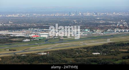 Vista aerea dell'Aeroporto Internazionale di Manchester guardando a nord attraverso le 2 piste principali verso lo skyline del centro citta' Foto Stock