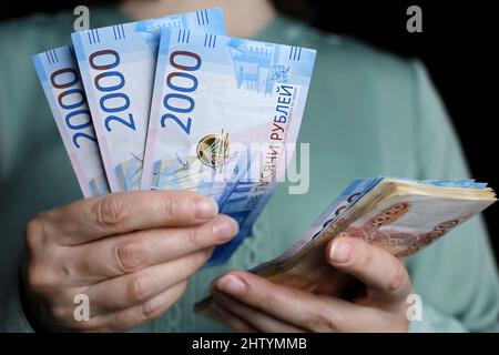 Rubli russi in mani femminili, pagamento in contanti, stipendio, inflazione o concetto di risparmio. Donna in ufficio vestiti contando carta valuta della Russia Foto Stock