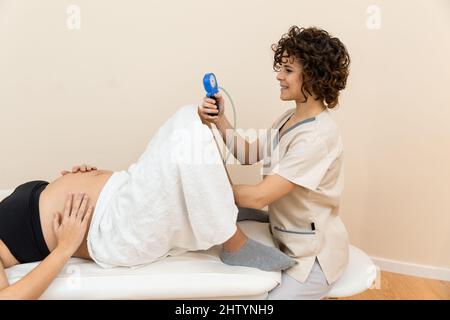 Ginecologo in possesso di un apparato muscolo pelvico del pavimento esercizio per preparare per la nascita di una donna Foto Stock