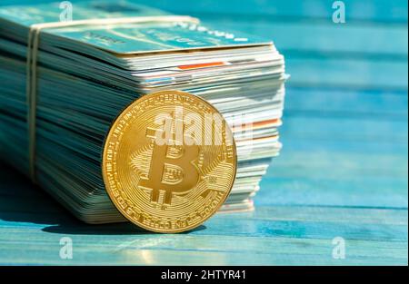 Monete in oro bitcoin simbolo vicino a una grande pila di carte di credito e carte regalo, criptovaluta, cripto digitale cambio valuta, pagamento alternativo, dit Foto Stock