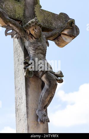 Gesù Cristo sulla croce vecchia pietra antica scultura coperta di muschio, cimitero figura oggetto primo piano dettaglio oggetto, nessuno. Cristianesimo, cattolico Foto Stock