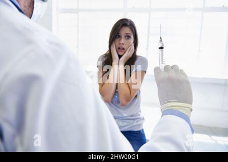 Questo non fa male un po'. Un medico che fa un'iniezione ad una donna. Foto Stock