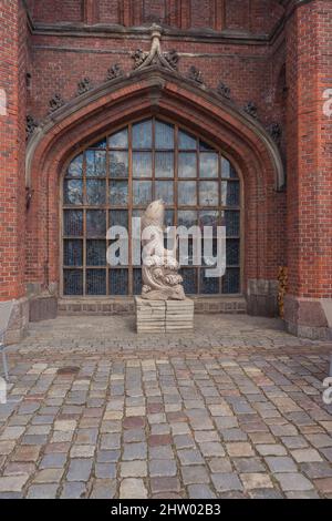 Kaliningrad, Russia - 17 maggio 2021: Statua di pietra di pesce di fronte al vecchio edificio in mattoni Foto Stock