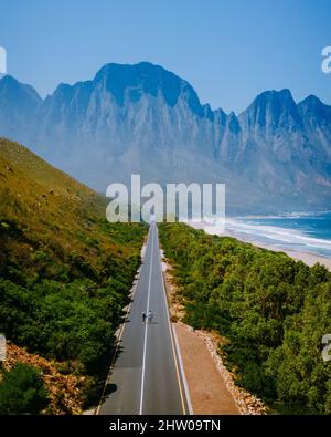 Kogelbay Beach Capo Occidentale Sud Africa, Kogelbay Rugged Coast Line con spettacolari montagne. Giardino route.Couple uomo e donne che camminano su strada, vista drone Foto Stock