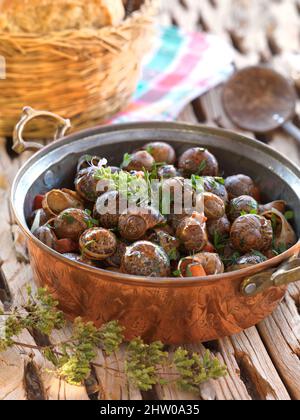 Una ricetta tradizionale greca da Creta, lumache al forno con burro all'aglio ed erbe Foto Stock