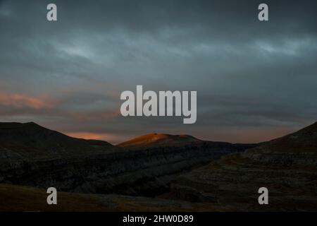 I primi raggi di luce appaiono in una mattina nuvolosa nella Valle d'Ordesa Foto Stock