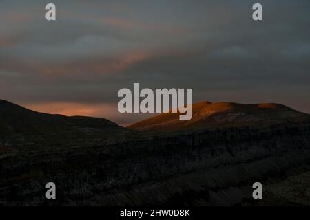 I primi raggi di luce appaiono in una mattina nuvolosa nella Valle d'Ordesa Foto Stock