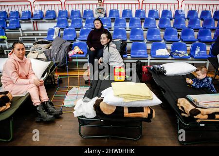 Una famiglia Ucraina si riposa in una scuola di sport Hall temporaneamente trasformato in un rifugio dove sono assistiti da volontari a Przemysl, in Polonia, come più di 300 mila persone già fuggito Ucraina per la Polonia a causa dell'invasione russa il 3 marzo 2022. Mentre l'esercito della Federazione russa ha attraversato i confini ucraini, il conflitto tra Ucraina e Russia dovrebbe costringere fino a 4 milioni di ucraini a fuggire. Molti dei rifugiati chiederanno asilo in Polonia. La maggior parte degli evasees arrivarono a città di confine come Przemysl e sono ricollocati nelle città interne. (Foto di Dominika Zarzycka/Sipa USA) Foto Stock