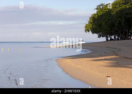 Spiaggia lambita dall'acqua dell'Oceano Indiano a Flic an Flac a Mauritius. La baia di Tamarin si lava contro la spiaggia sabbiosa. Foto Stock