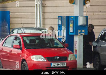 Bantry, West Cork, Irlanda giovedì 3 marzo 2022; il costo del carburante è aumentato bruscamente a causa della guerra in corso tra Russia e Ucraina e l'invasione da parte della Russia. Un barile di olio ha ora raggiunto $100 un barile che ha un effetto a catena sugli automobilisti. Oggi, presso la stazione di servizio Maxol di Bantry, il prezzo della benzina è di 181,9per litri e del diesel di 171,9 litri. Una donna riempie la sua auto di carburante. Credit ed/Alamy Live News Foto Stock