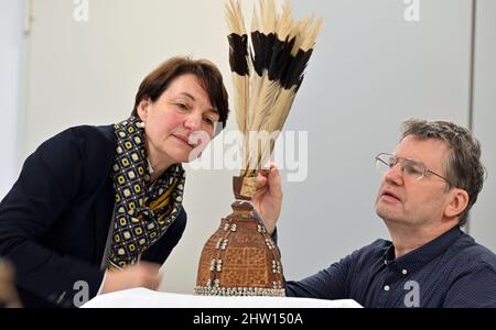 03 marzo 2022, Turingia, Gotha: Peter Mildner, tassidermista zoologica, e Kerstin Volker-Saad, Responsabile del progetto scientifico, guarda il cappello decorato di un capo Dayaker del Borneo. Diversi oggetti saranno esposti in occasione di un evento stampa per segnare la conclusione del progetto 'Dialogue of Worlds. Apertura di Ethnographica". Dopo un anno e mezzo, la Fondazione del Castello di Friedenstein a Gotha ha ha completato la "indicizzazione esemplare di Etnografica nella Collezione di Gotha del Castello di Friedenstein" nell'ambito del progetto "Gotha Transdigital". In totale sono stati digitalizzati quasi 1000 oggetti. Foto: Martin Schu Foto Stock