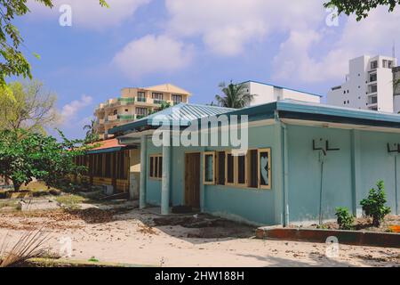 Rovine delle Case di legno con il Maldivian Hotel Building sullo sfondo, Maafushi Island Foto Stock