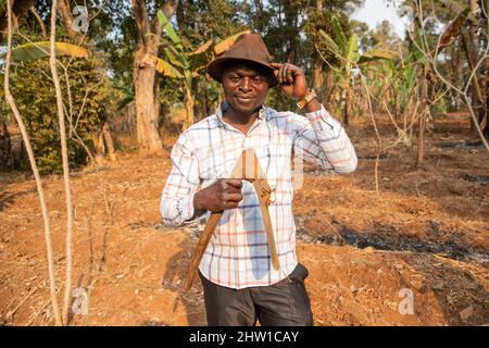 Un agricoltore di successo nel suo campo tiene la zappa in mano. Foto Stock