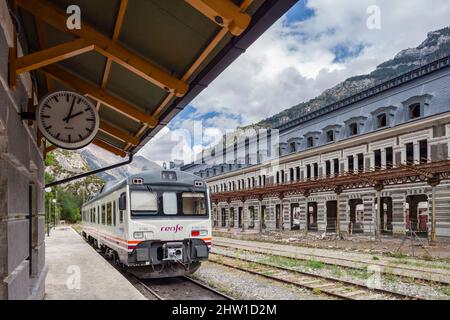 Spagna, Aragona, Huesca, Canfranc, Stazione ferroviaria Internazionale (altitudine 1200 metri), un treno locale spagnolo da Jaca è parcheggiato di fronte alla facciata dell'edificio principale, trasformato in un museo della vecchia linea ferroviaria Pau-Zaragoza, abbandonato dal 1970, la riabilitazione della stazione in un hotel di lusso Foto Stock