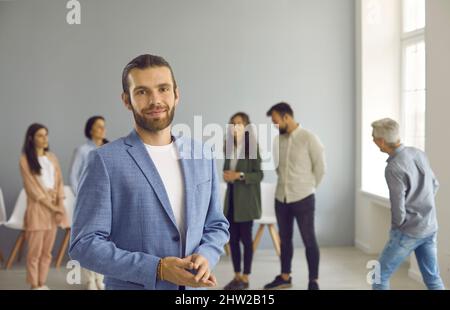 Ritratto di buon riuscito uomo d'affari giovane o vettura di affari che si levano in piedi in ufficio Foto Stock