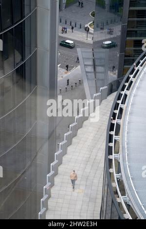 Mentre la guerra in Ucraina continua e il finanziamento del denaro russo nella capitale rimane controverso, un uomo cammina lungo una terrazza sul tetto con uno sfondo di altri lavoratori della città e l'architettura d'ufficio, il 3rd febbraio 2022, nella città di Londra, Inghilterra. Foto Stock