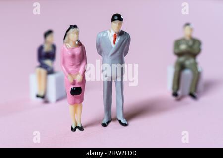 alcune persone in miniatura in relazione l'una all'altra su una superficie colorata Foto Stock