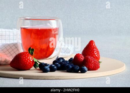 bella gelatina di bacche in un vetro trasparente, bacche fresche sono sparsi nelle vicinanze Foto Stock