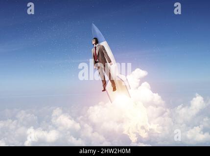 Persona d'affari in aviator hat a volare su un razzo Foto Stock