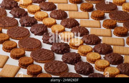 Foto ravvicinata di splendidi biscotti glassati al cioccolato, cracker rotondi e rettangolari impilati in file con un bel motivo Foto Stock