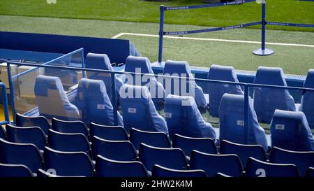 Vista dei cavalletti blu vuoti nelle file anteriori. Azione. I primi posti in stand per persone VIP allo stadio di calcio. Sedie comode in costose prime plac Foto Stock