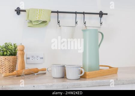 Cucina moderna con mensole, cibo, spezie e angolo cottura dispares.kitchen con vari utensili di cucina tra cui piante, utensili di legno, contenitore di vetro Foto Stock