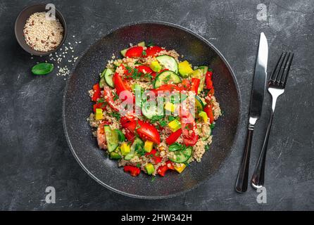 Insalata vegetariana di Levantine con bulgur, quinoa, avocado, pomodori, cetrioli ed erbe fresche. Insalata di tabbouleh. Vista dall'alto, spazio di copia. Foto Stock