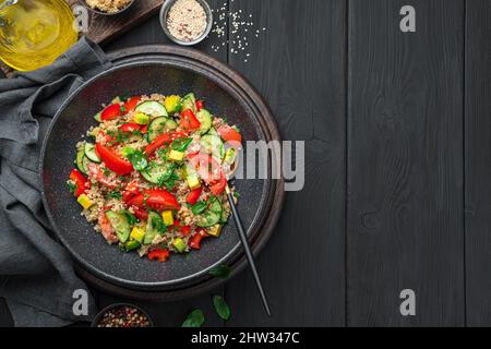 Insalata di tabbouleh con quinoa e avocado. Insalata vegetariana di Levantine con bulgur, quinoa, pomodori, cetrioli ed erbe fresche. Foto Stock