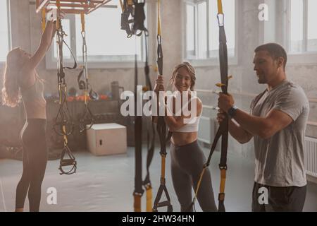 Belle donne che si allenano con personal trainer al chiuso Foto Stock