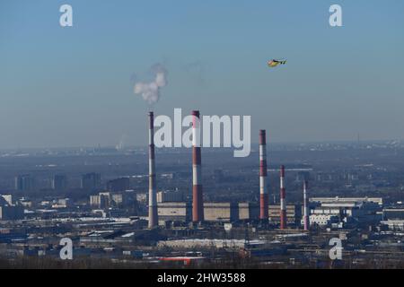 Megapolis. Elicottero del Ministero delle situazioni di emergenza nel cielo sopra la città. Infrastrutture urbane, fumo dal riscaldamento Foto Stock