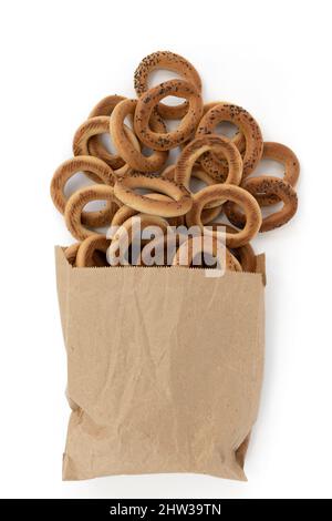 mucchio di bagel con semi di papavero in un piccolo sacchetto di carta isolato su sfondo bianco, vista dall'alto, concetto di panetteria alimentare Foto Stock