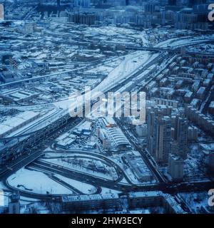 Le aree urbane e le autostrade sono coperte di neve. Vita quotidiana della città, vista dall'alto di Mosca in una giornata invernale, fotografia aerea Foto Stock