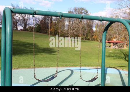 Altalena da gioco in acciaio con un campo Foto Stock