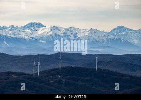 Una vista panoramica delle turbine eoliche sullo sfondo delle alte montagne innevate Foto Stock