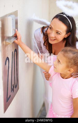 Trick o delizia. Scatto corto di una madre che aiuta la figlia mentre il trucco-o-trattando. Foto Stock