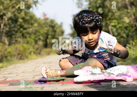 Tema Holi colorato - Ritratto di carino indiano vestendo tondi colori e dipinti in polvere di colore Holi chiamato Rang Gulal Foto Stock