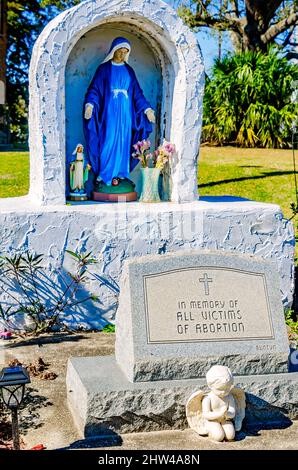 Una statua della Vergine Maria si trova accanto a un monumento alle vittime dell'aborto presso la chiesa cattolica di Santa Margherita a Bayou la Batre, Alabama. Foto Stock